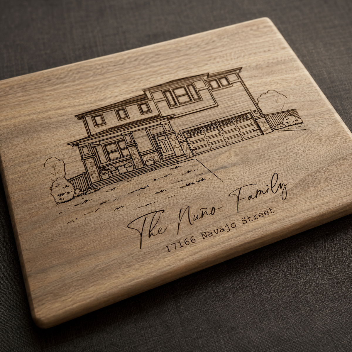 Custom engraved house portrait cutting board lying flat on a table